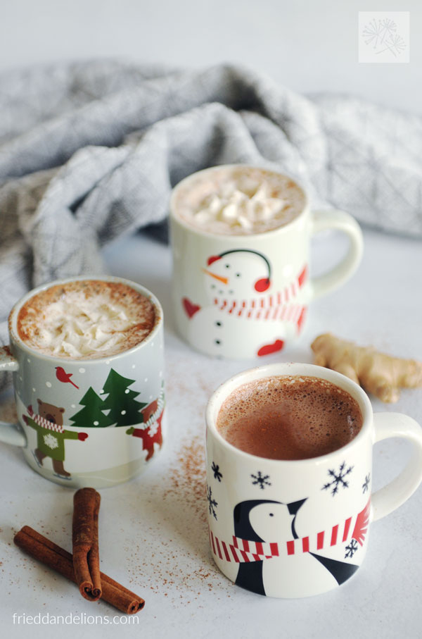 3 children's mugs of vegan hot chocolate with ginger and cinnamon in the backgroun