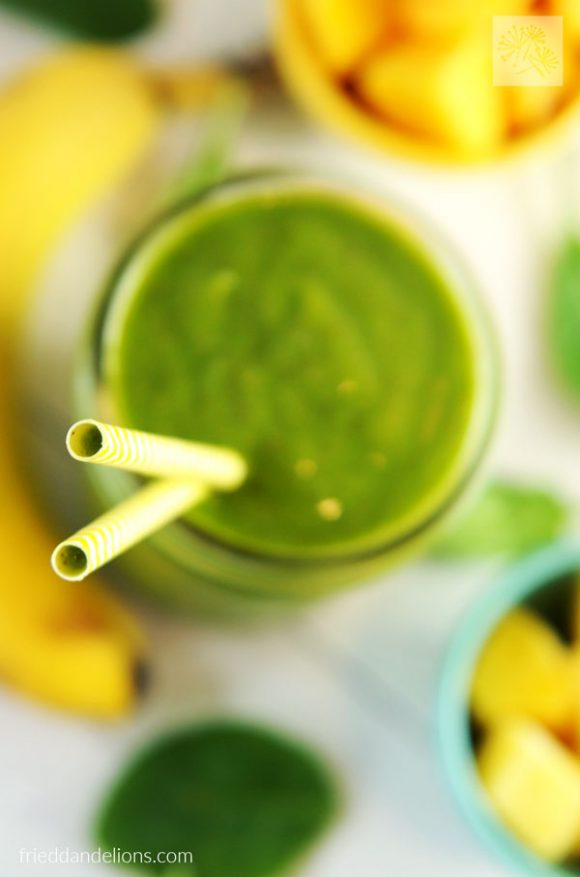 overhead shot of citrus explosion green smoothie with yellow straws in focus