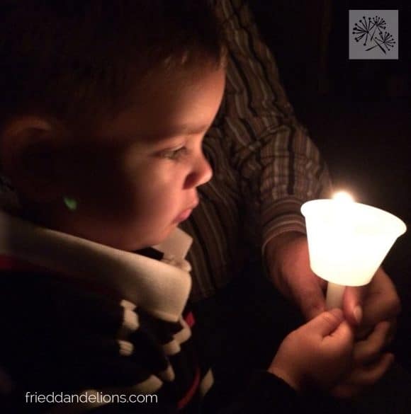 boy holding candle at Christmas Eve service