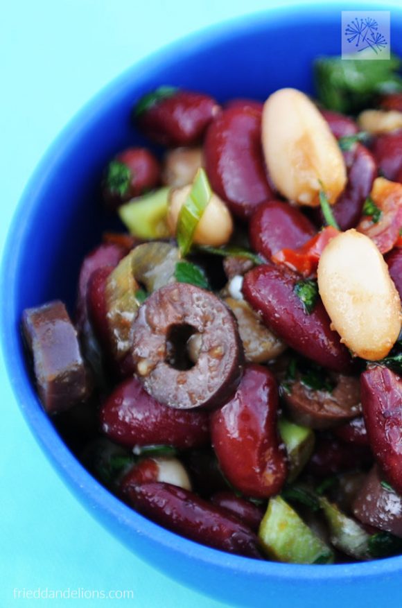 vertical close up of balsamic bean salad in blue bowl
