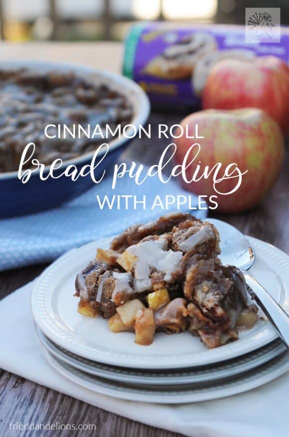 dish of Cinnamon Roll Bread Pudding with text overlay, apples in the background, and white plates