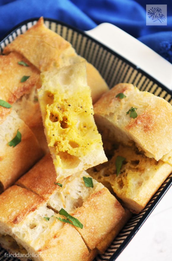 close up of dish of easy vegan garlic bread with slice on top