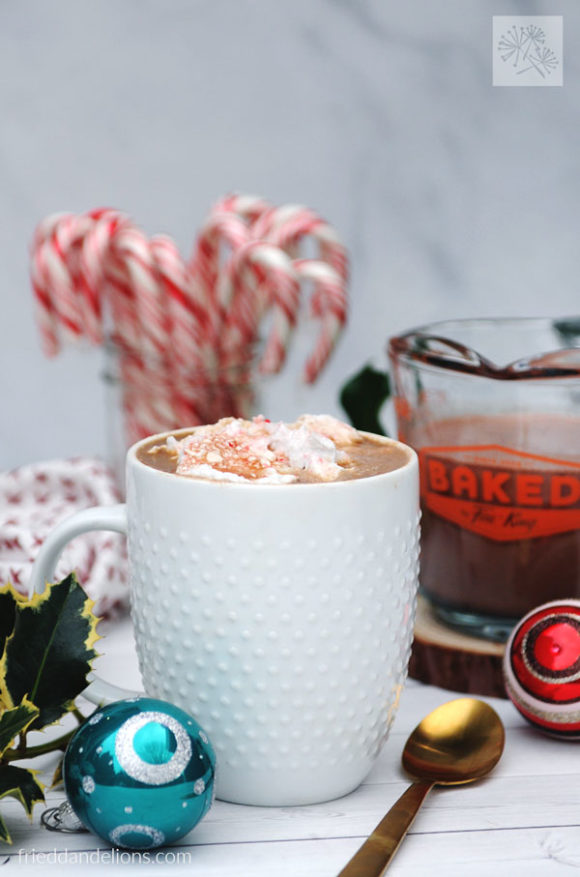 mug of coffee made with dairy free peppermint mocha creamer with candy canes in the background