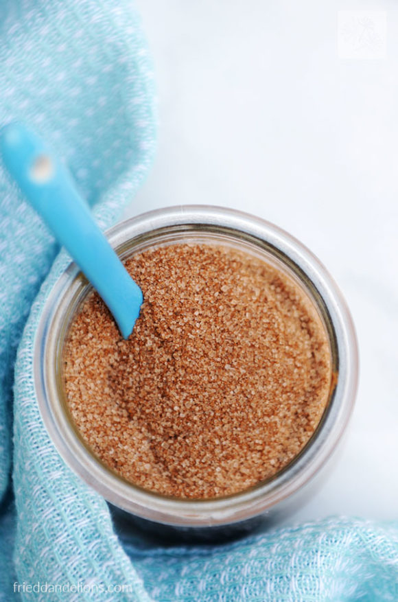jar of cinnamon sugar toast topping with blue spoon