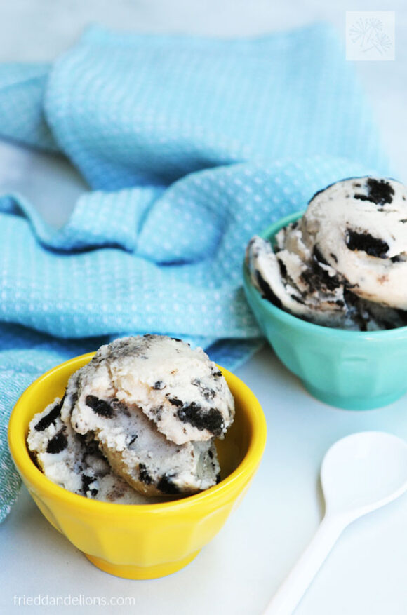 yellow and blue bowls of dairy free cookies and cream ice cream with blue napkin and white spoon