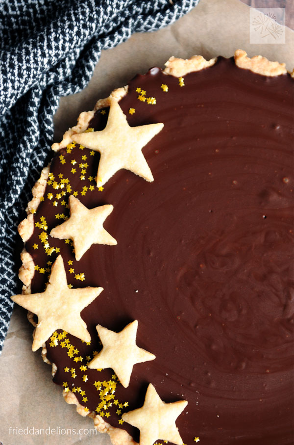 close up view of vegan chocolate ganache tart with cookie stars on top