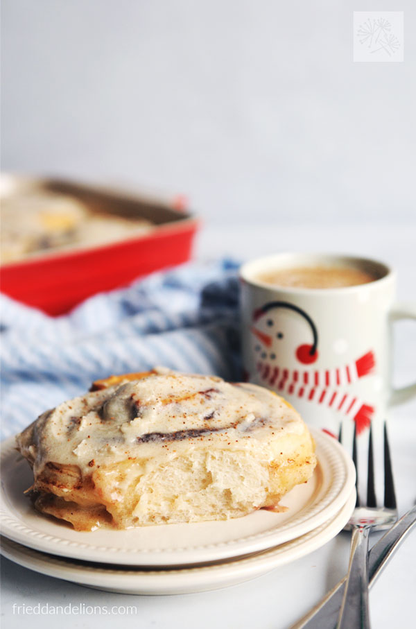close up view of tiktok cinnamon rolls with mug of eggnog in background