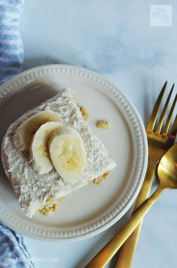 overhead view of banana coconut snack cake with gold silverware